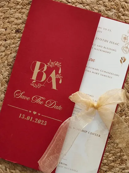 A trendy customized wedding invitation in a vibrant red. The design features a gold foil monogram and a "Save The Date" message.