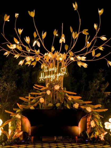 A romantic and whimsical photo spot for a sangeet. This custom-made tree of light with a neon "It was Always you" sign creates a beautiful, intimate setting for couple portraits.