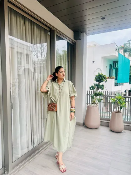 A full look of the green kaftan dress paired with the handcrafted wooden purse from my brand.