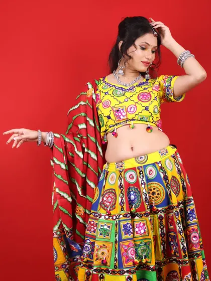 A playful pose in a traditional Garba outfit. The makeup features a pop of yellow on the eyes to match the colorful attire.