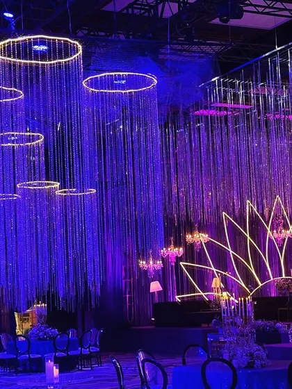 This angle highlights the hanging crystal installations and the neon lotus stage. The deep blue and purple lighting creates a moody and glamorous atmosphere, perfect for a night of music and dancing.