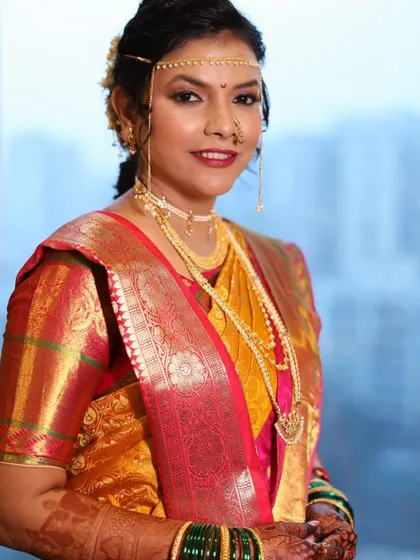A side profile showcasing the elegant hairstyle and the traditional mundavalya. The makeup is flawless, ensuring she looks perfect from every angle.