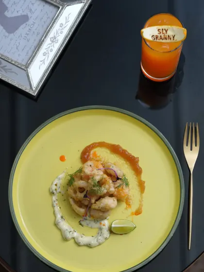 A beautifully plated seafood dish from my four-course lunch menu, paired with a refreshing orange mocktail.