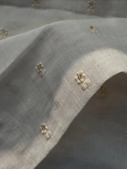 A close-up of our white embroidered gauge linen, showcasing the delicate texture and dyeable quality that makes it so versatile.
