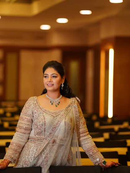 A confident pose in the event space. The bride looks poised and beautiful, her makeup perfectly complementing her elegant attire and the sophisticated ambiance.