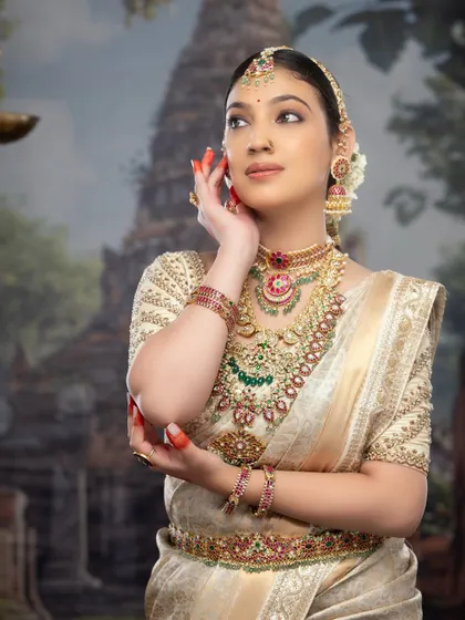 A side profile showcasing the complete look, from the elegant hairstyle adorned with flowers to the perfectly draped saree.