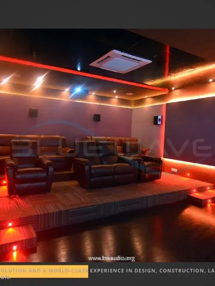 A home theater built on a raised wooden platform, creating a distinct cinema zone within a larger room. The red LED step lighting adds a dramatic flair while ensuring safety in low light.