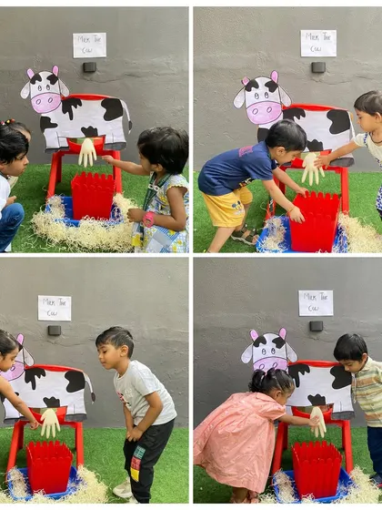 Teamwork at the farm. Two children work together to milk the cow, a playful exercise that also teaches cooperation and social skills.