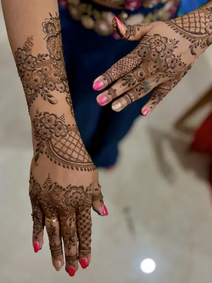 A beautiful floral mehendi design for a client attending her sister's wedding, with patterns extending up the arm.