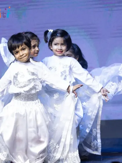 Children in white costumes dance as the wind. Their synchronized movements create a beautiful depiction of the element Vayu.
