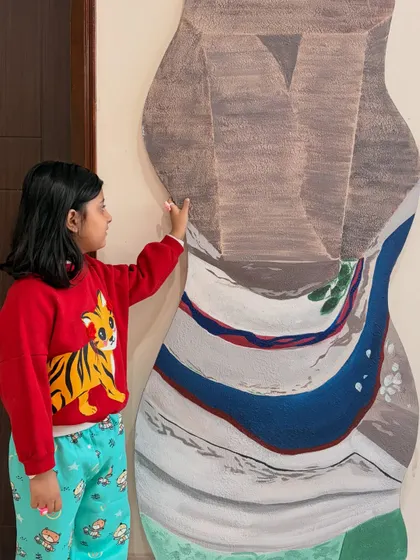 My client's daughter interacting with the large-scale abstract art piece, giving a sense of its impressive size and presence in the room.