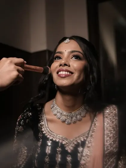 A behind the scenes moment with Poojitha for her reception. I'm applying a touch of blush to enhance her dewy, glowing skin. This look is all about modern glamour, perfect for an evening of celebration.