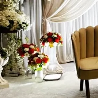 Small floral arrangements in glass vases, used as accent pieces on the stage. These details help to fill the space and carry the floral theme throughout the entire setup.