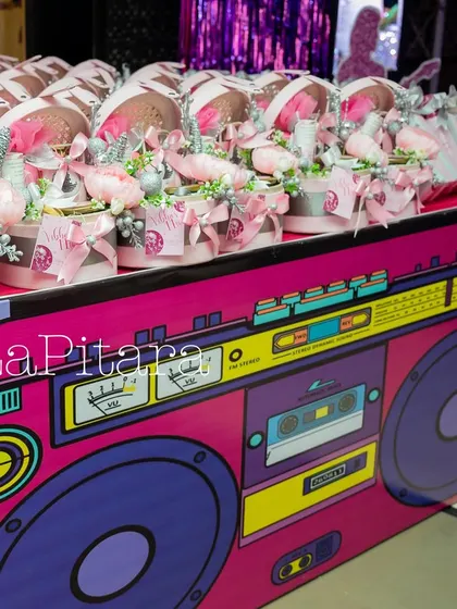 A party favor table disguised as a giant retro boombox, a creative and thematic way to display gifts for guests.
