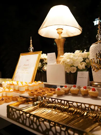Our dessert tables are designed to be an elegant focal point. This setup features a variety of bite-sized treats, including miniature tarts and dessert shots, beautifully arranged with ambient lighting and floral decor for a sophisticated late-night indulgence.