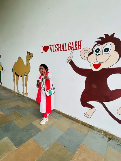 Posing with the fun murals at Vishalgarh. My job is to find the fun in every corner of an event and share that excitement with everyone, whether it's on stage or during a photo opportunity.