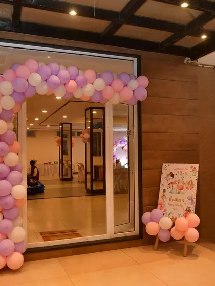 This fairytale-themed entrance includes a simple pastel balloon arch and a matching welcome board, setting a sweet and gentle tone for the celebration inside.