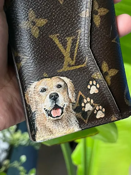 A close-up of another custom LV wallet, this time featuring a happy golden retriever and tiny paw prints. I use specialized paints to ensure the artwork is durable and lasts.