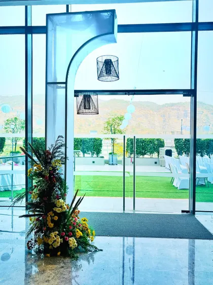 An example of our indoor decor details. This modern archway with hanging cage lamps perfectly frames the view of the outdoor lawn, seamlessly connecting the indoor and outdoor spaces of the venue.