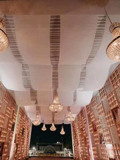 An elegant entrance corridor with cascading chandeliers and candle-lit walls. This is an example of how we transform spaces to create a grand and welcoming atmosphere.