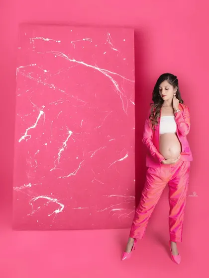 A stylish and modern maternity portrait. The pink suit is a fantastic choice for a mom-to-be who wants her photos to be as bold and vibrant as she is.