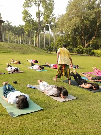 Guiding the group through 'Makarasana' (Crocodile Pose). This pose is excellent for relaxing the spine and lower back after a workout.
