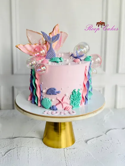 Making waves with this magical mermaid cake. This design features a beautiful mermaid tail, seashells, and underwater treasures.