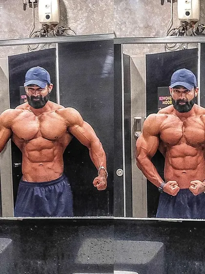 A mirror shot practicing the front lat spread and most muscular poses. The mirror is a bodybuilder's most honest tool for critique and refinement.