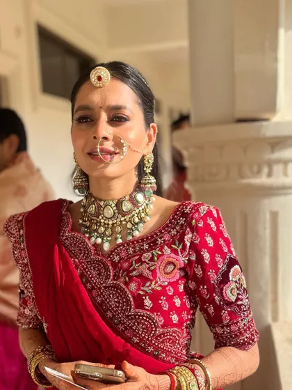 A soft glam look for a traditional bride. The minimal makeup approach allows the beauty of the red saree and heritage jewelry to shine.