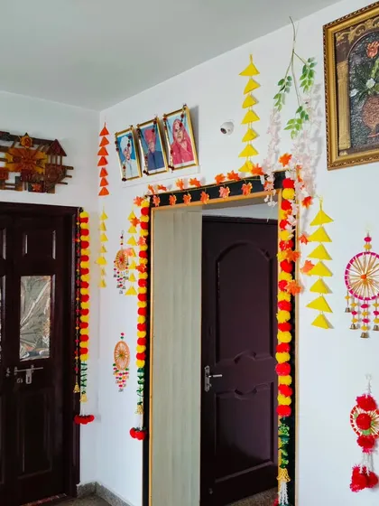 Doorway and wall decorations for a home festival. I used traditional marigold garlands and handmade hangings to welcome guests right from the entrance.