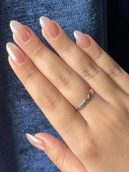 A beautiful example of 'glazed donut' nails, featuring a sheer, pearly chrome finish on almond-shaped nails for a chic and trendy look.