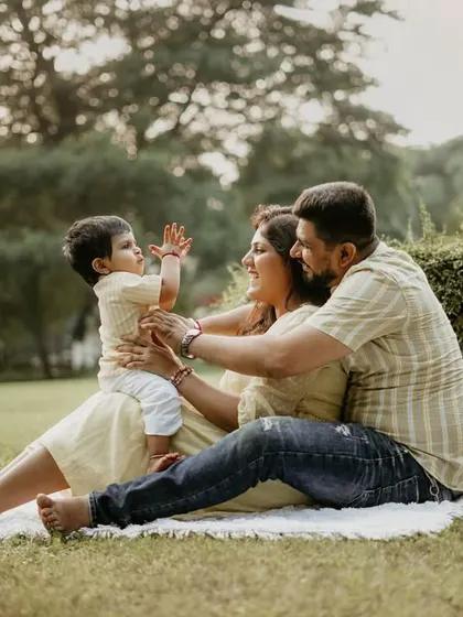 A playful moment on the blanket, with the parents engaging their baby in a game. The genuine laughter and interaction are what make this photo special.