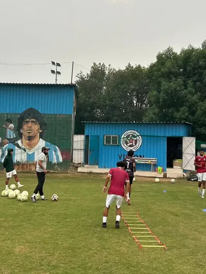 A wider view of an agility ladder drill session at the academy, with the iconic mural of football legends in the background, inspiring the next generation.