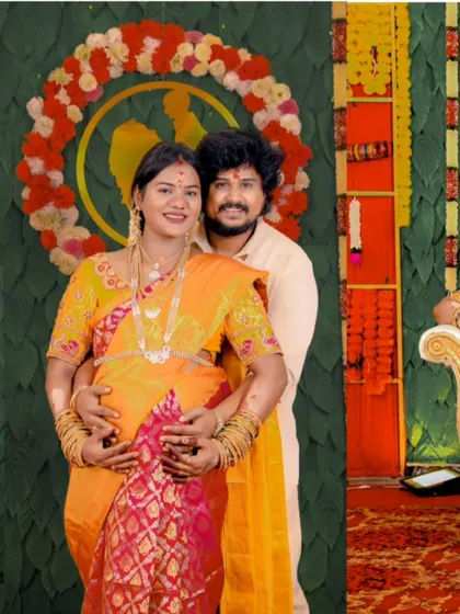 A happy, posed portrait of the couple at their baby shower. Their bright smiles and coordinated outfits reflect the joyous atmosphere of the celebration.