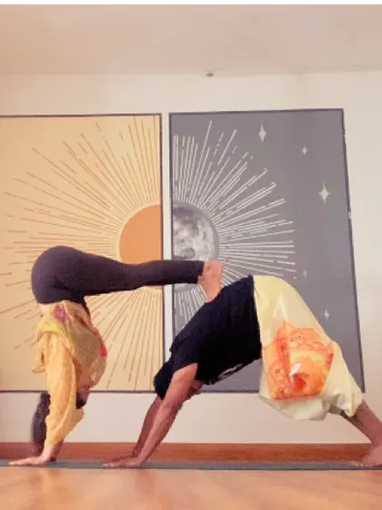 A fun partner pose combining downward dog with a handstand press. This builds trust, communication, and a lot of upper body strength.