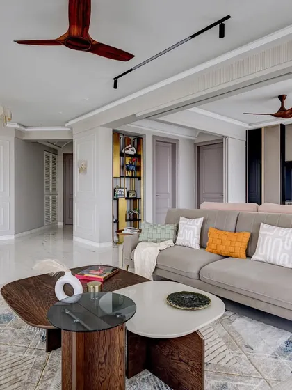 Another angle of the 'Urban Tranquility' living room, showing the flow into the entryway. The design uses consistent colors and materials to create a harmonious and expansive feel.