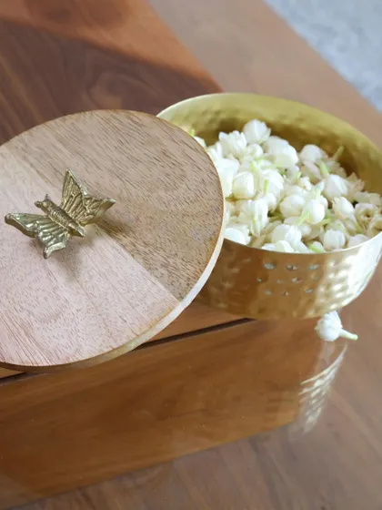 A close-up of our wooden and hammered gold keepsake box, topped with a delicate butterfly. This piece is perfect for adding a touch of nature-inspired elegance to your dresser or shelf.