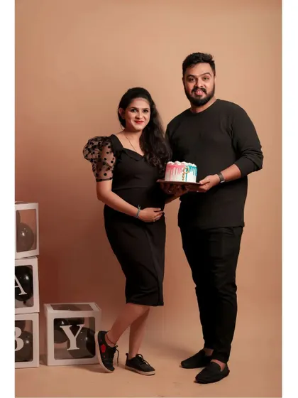 A sweet moment during a maternity shoot, where the couple holds a cake. This shows how you can bring your own props to celebrate, using our 'BABY' blocks and beige backdrop.
