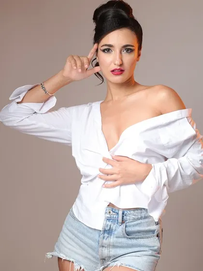 A classic fashion portrait in a white shirt and denim shorts. The pose is confident and stylish, making it a great addition to any model's portfolio.