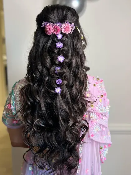 Minimal beauty at its best. A simple half-up braid adorned with a gradient of pink and purple flowers.