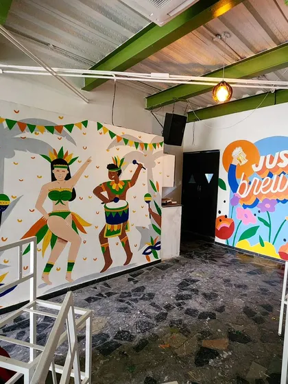 We brought a carnival vibe to Cirkus HSR with two distinct murals. This view shows the carnival dancers on one wall and a colorful brewery-themed piece on the adjacent wall.