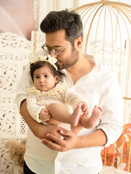 A tender moment as a father kisses his baby's head. This close-up shot captures the quiet affection in a family.