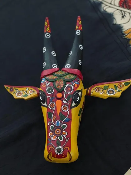 This yellow Nandi features a central panel of intricate floral work, reminiscent of Kalamkari, set against a dark, patterned background.