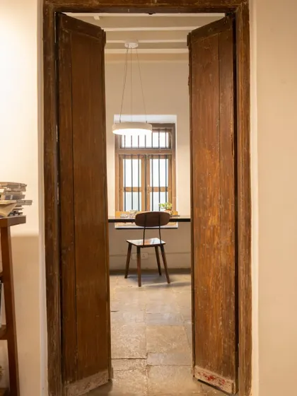 A simple doorway in our studio. The worn, original wooden doors open into a quiet workspace, showing the beauty in imperfection and the stories held within old materials.