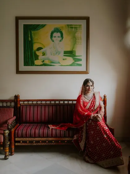 A classic bridal portrait, with the bride seated elegantly in her full wedding attire.