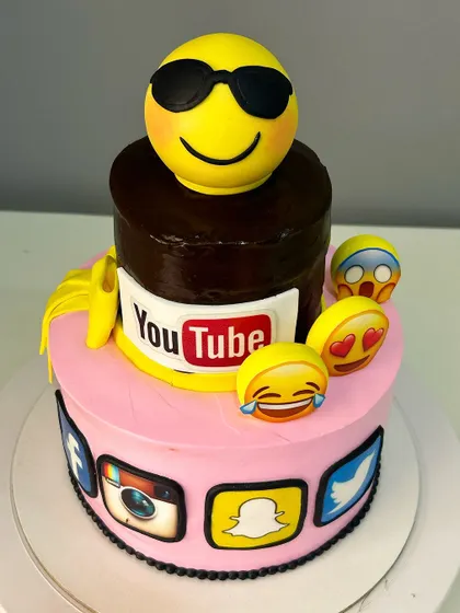 Another angle of the social media themed cake, showing the different emoji expressions.