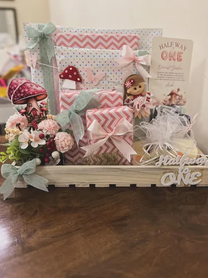 I love celebrating all the little milestones, including the quirky ones. This "Halfway to One" hamper was designed for a six-month celebration, using a whimsical fairy and mushroom theme to create a magical gift for a baby girl's special day.