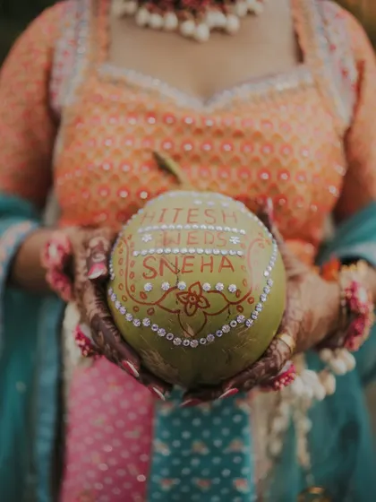 A creative detail shot of a coconut personalized with the couple's names for the Haldi ceremony.