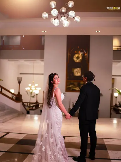 A "follow me to" style shot inside a grand hotel lobby, capturing the couple walking hand-in-hand after their Christian wedding ceremony.