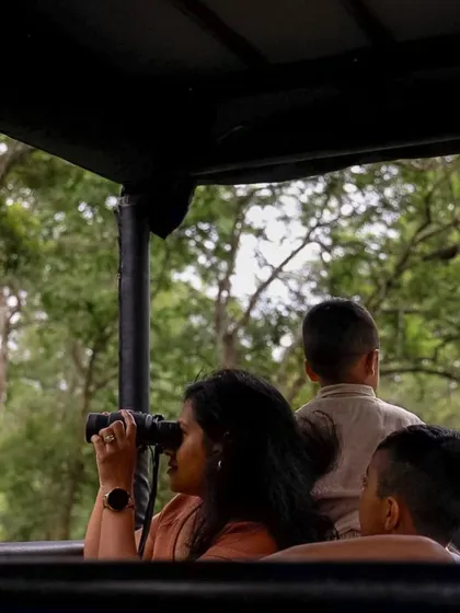 A guest uses binoculars to get a closer look at the wildlife during a safari. It’s these moments of quiet observation and discovery that make the experience so special.